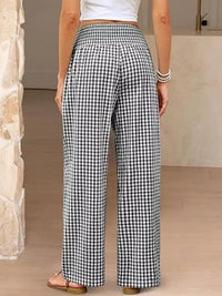 Person wearing black and white checkered pants indoors.