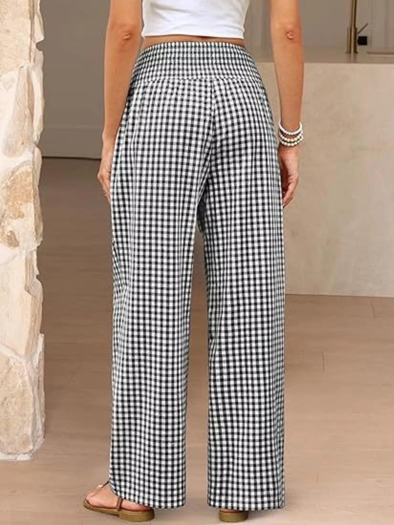 Person wearing black and white checkered pants indoors.