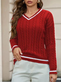 Red cable knit sweater with white trim worn by a person against a neutral background