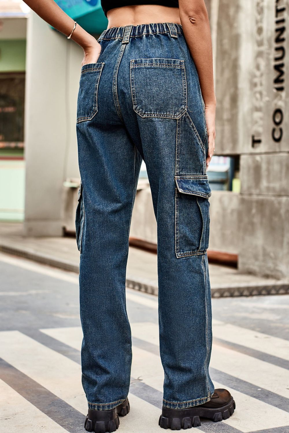 Person wearing blue cargo jeans standing on a city street.