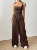 Woman wearing a burgundy jumpsuit on a plain background