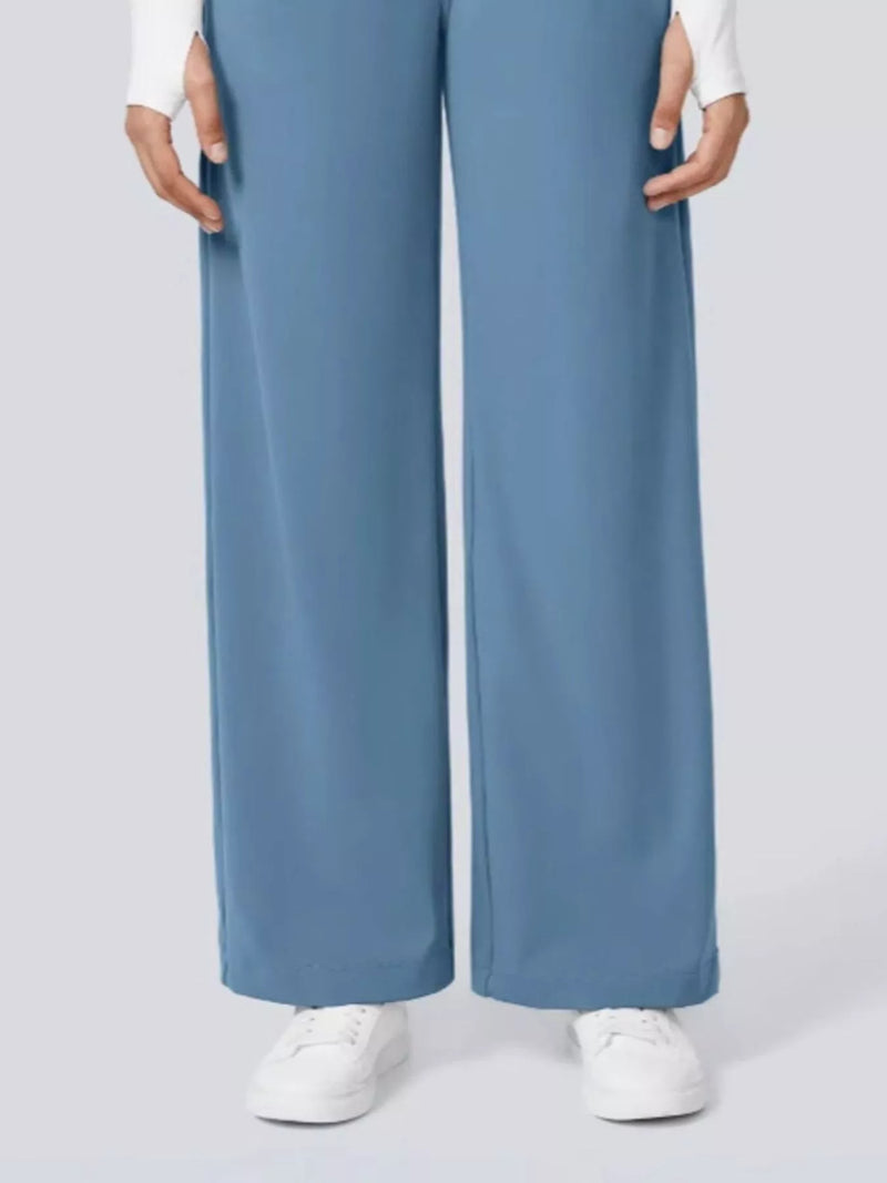 Blue wide-leg pants worn by a person on a light gray background