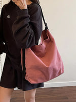 Person holding a pink handbag against a neutral background