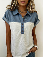 Woman wearing a two-tone shirt with denim and beige sections on a plain background
