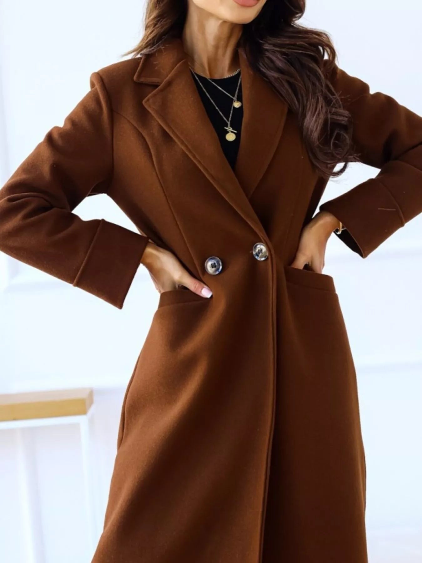 Brown coat worn by a person with a blurred background