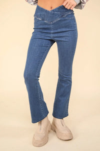 Blue jeans worn by a person on a beige background