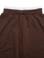 Brown textured pants with a drawstring on a white background