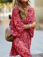Woman wearing a red patterned dress with a blurred background