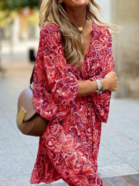Woman wearing a red patterned dress with a blurred background