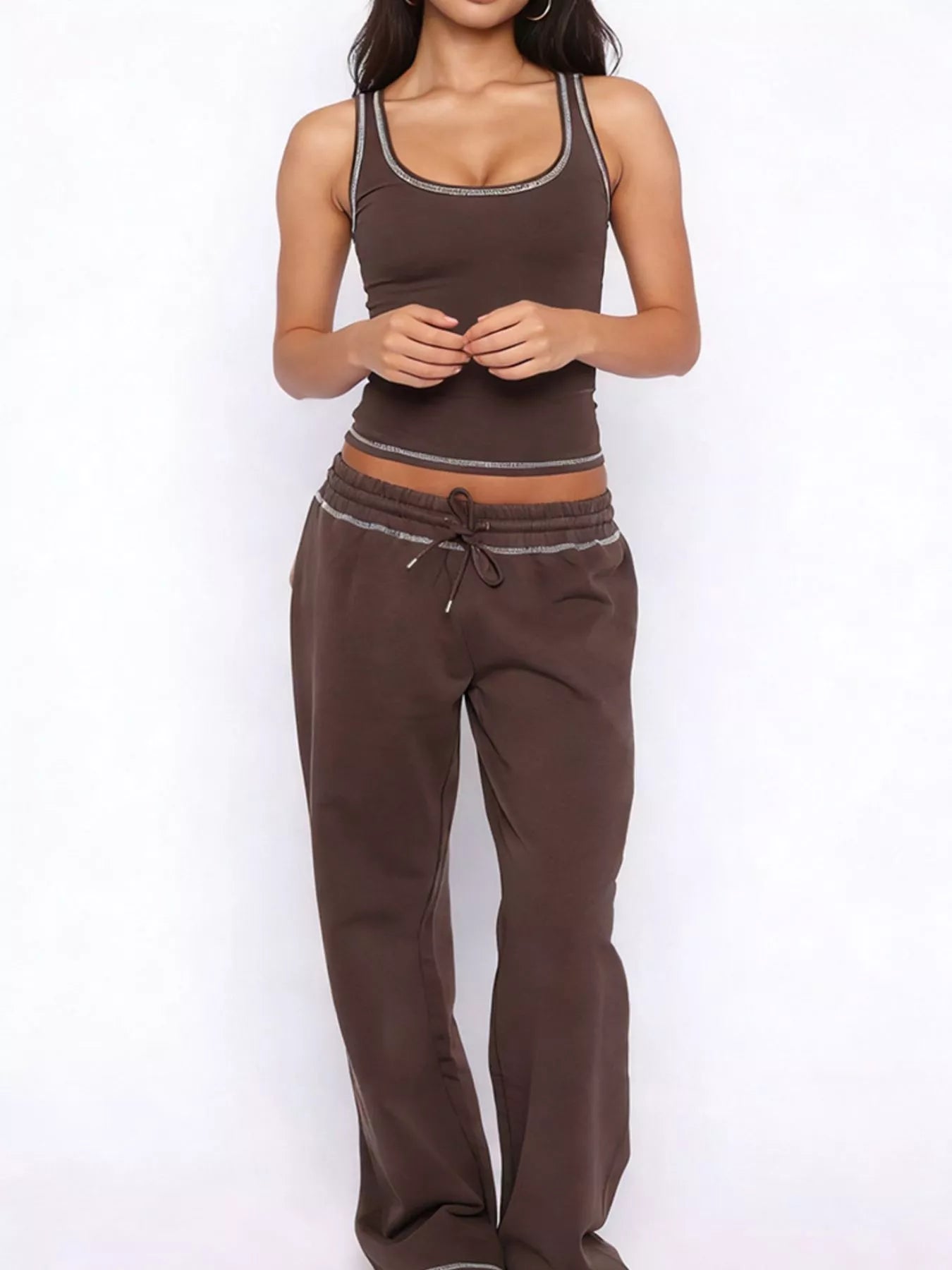 Woman wearing a brown tank top and pants on a white background
