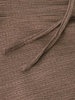 Close-up of a brown fabric texture with a single thread