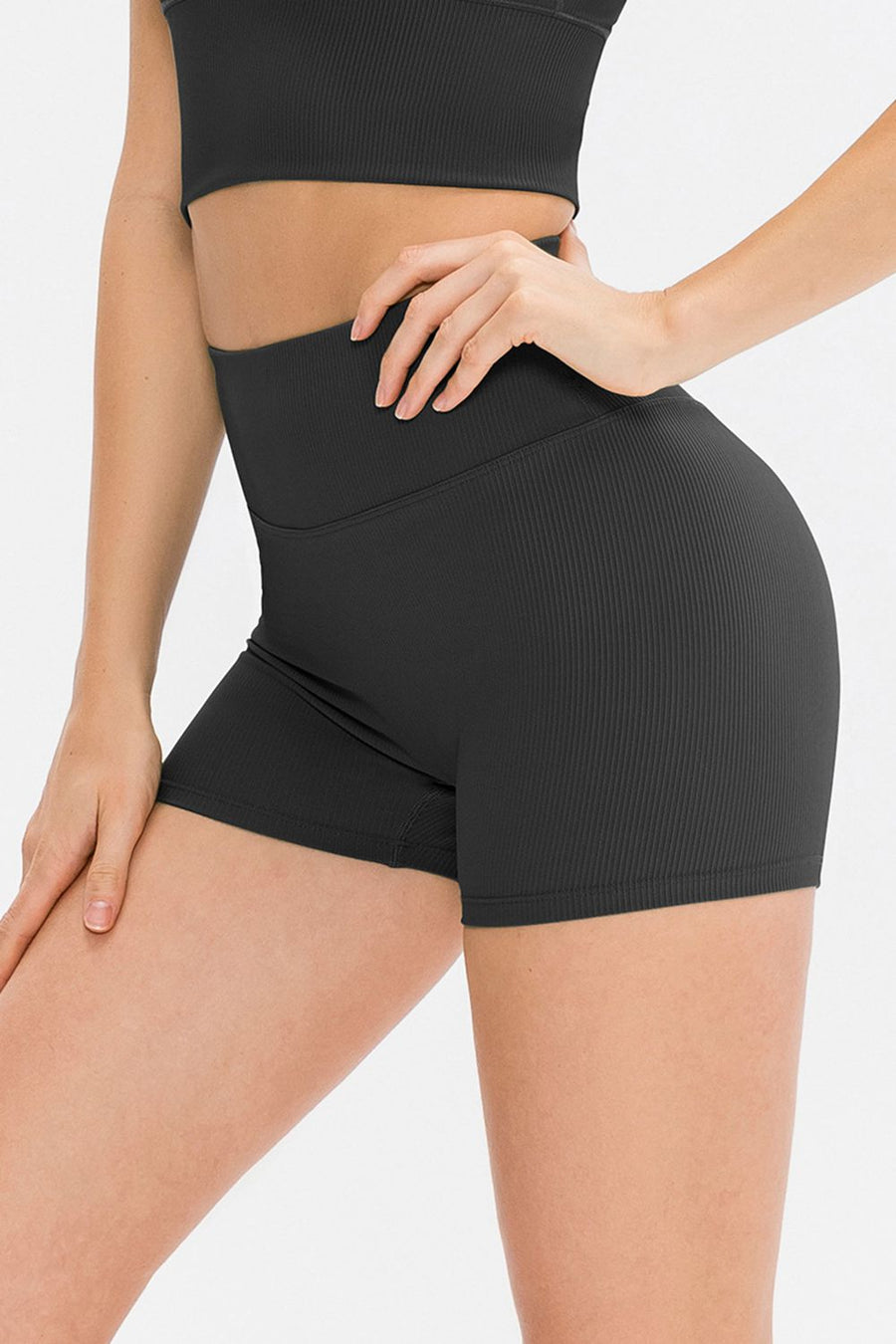 Person wearing black athletic shorts on a white background