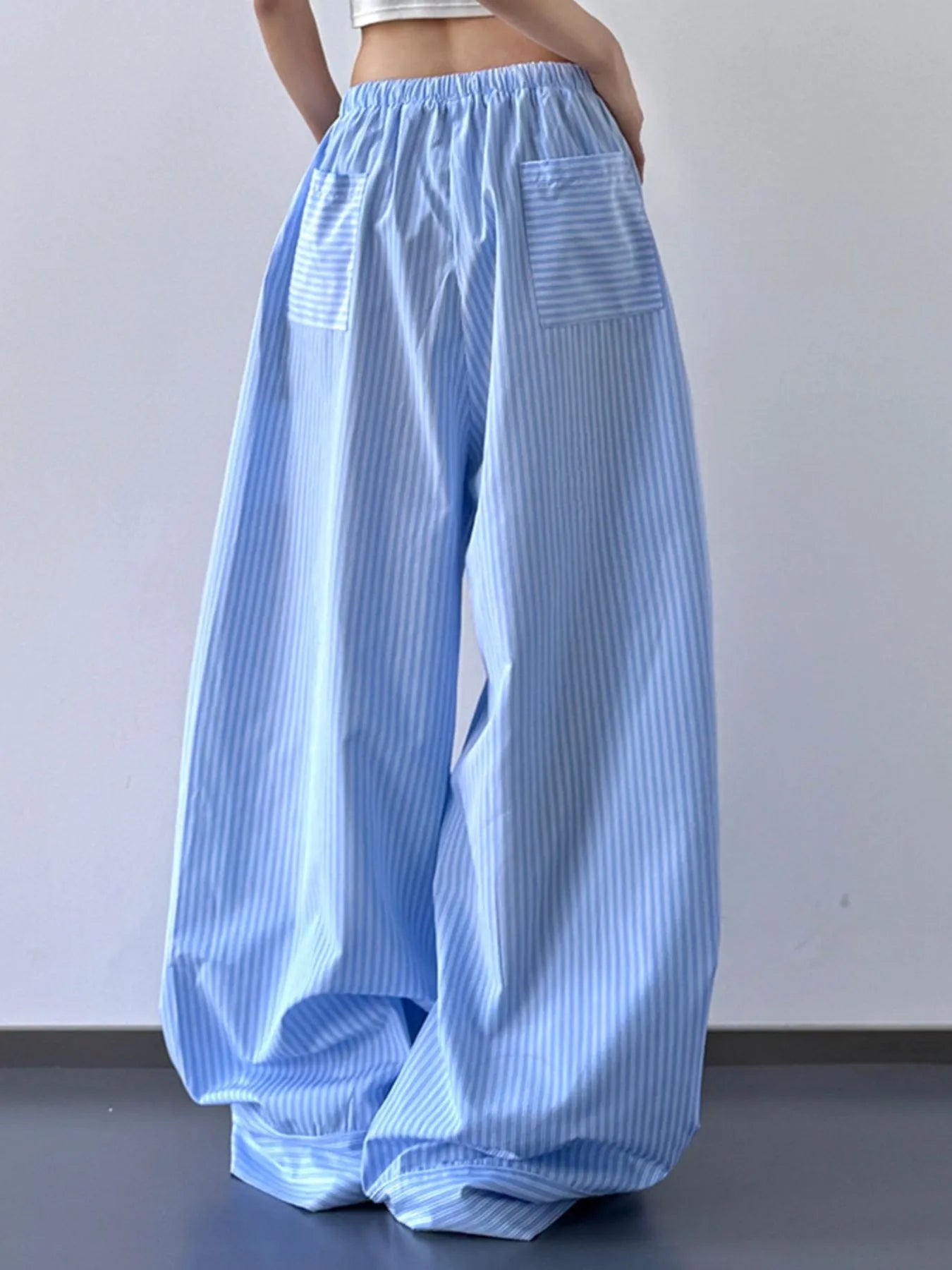 Blue striped wide-leg pants worn by a person against a plain background