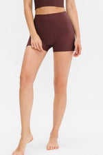 Person wearing brown athletic shorts on a white background