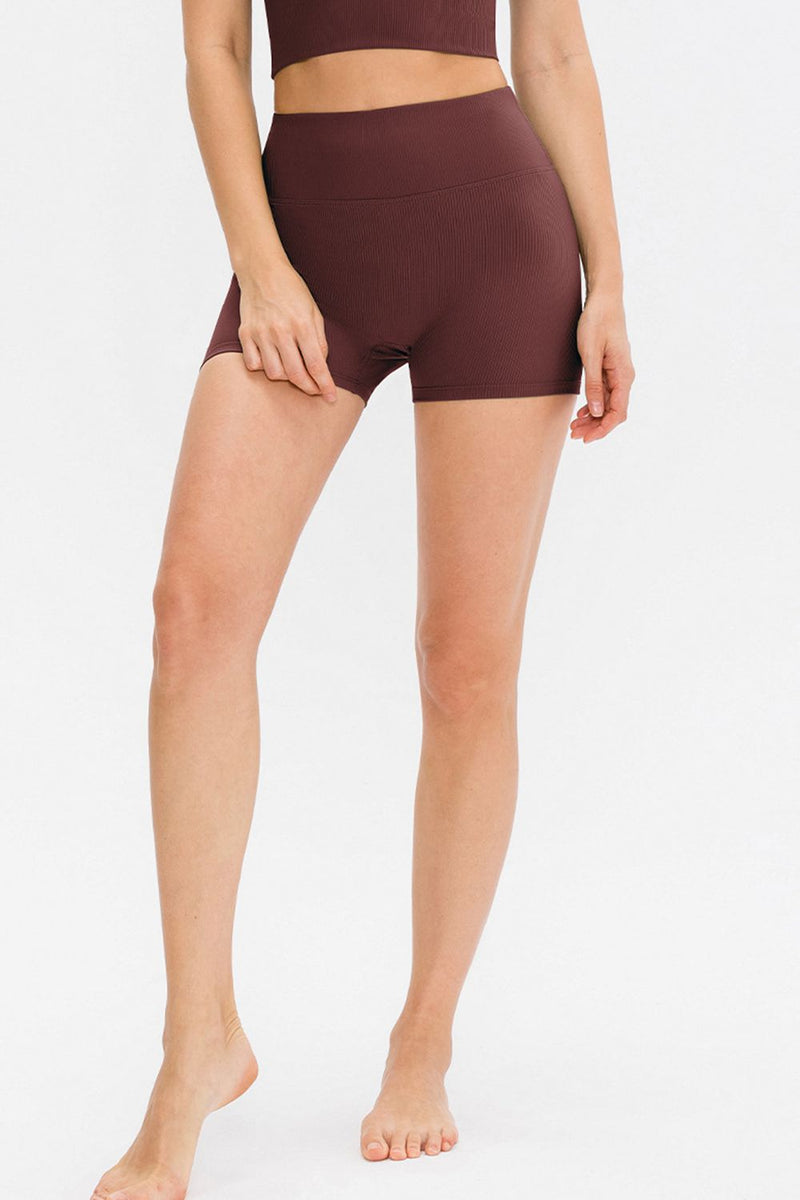 Person wearing brown athletic shorts on a white background