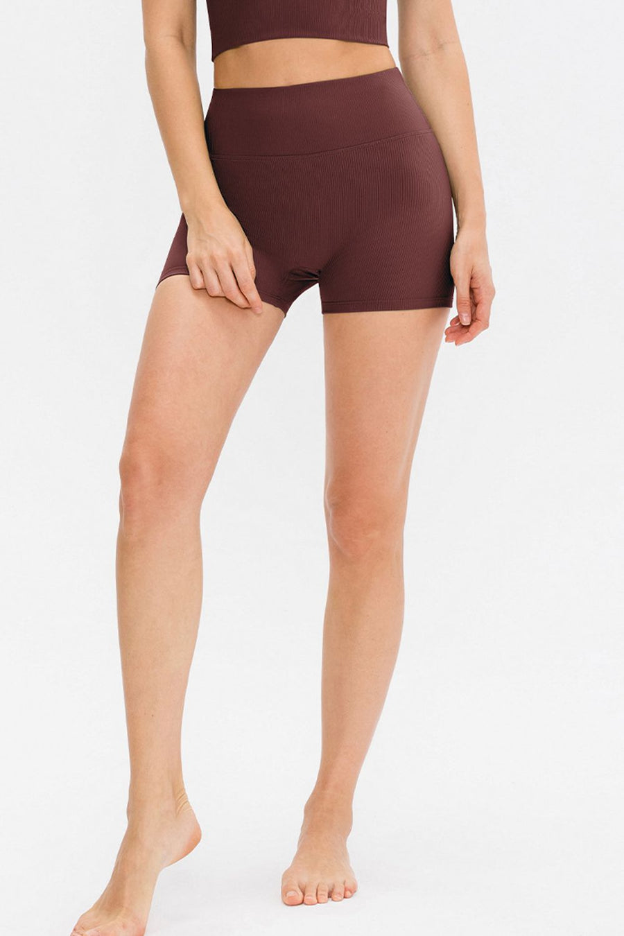 Person wearing brown athletic shorts on a white background