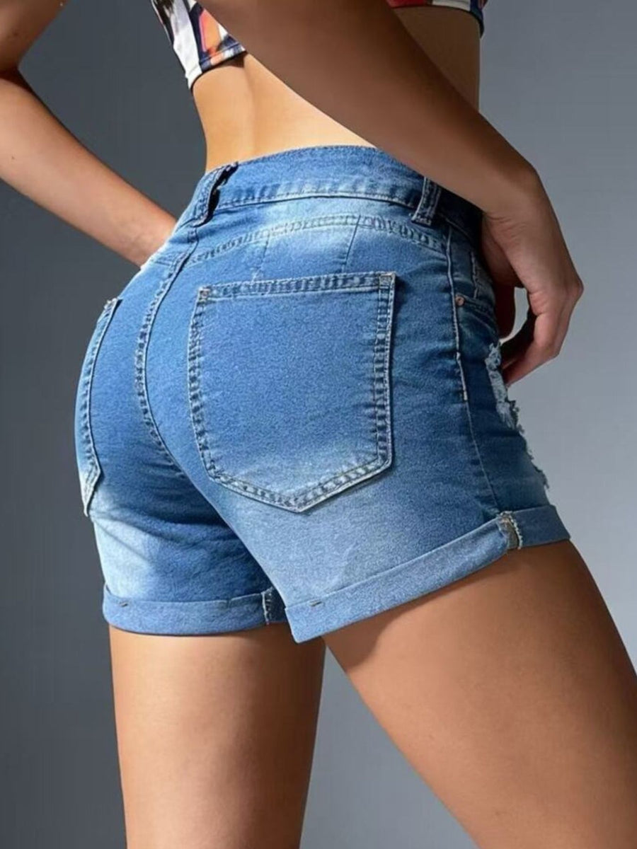 Person wearing blue denim shorts on a gray background