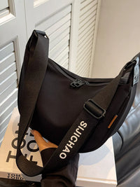 Black shoulder bag with 'SICHUA' branding on a surface with a blurred background