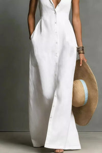 Person wearing a white dress holding a straw hat against a neutral background
