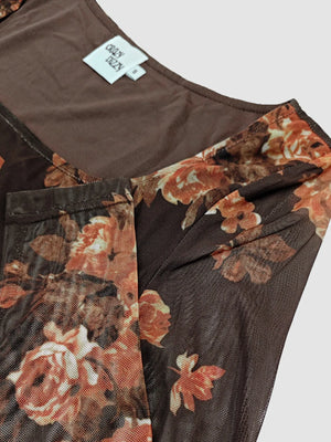 Floral-patterned garment with a visible brand tag on a plain background