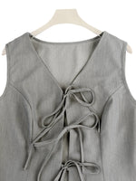 Gray sleeveless top with a tie detail on a hanger against a white background
