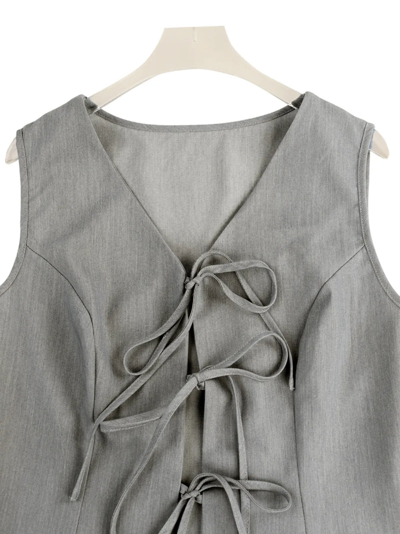 Gray sleeveless top with a tie detail on a hanger against a white background