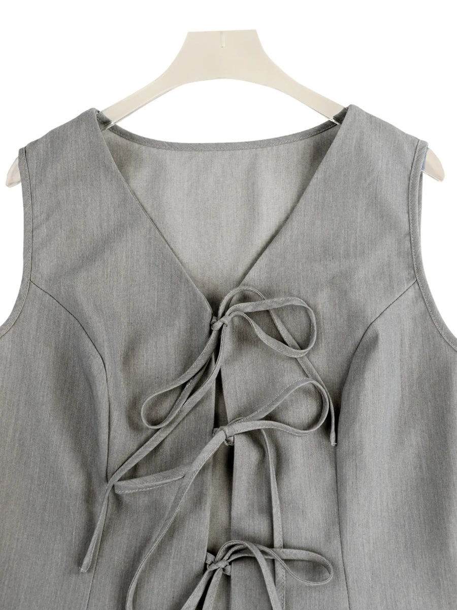 Gray sleeveless top with a tie detail on a hanger against a white background