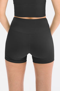 Black athletic shorts worn by a person on a white background