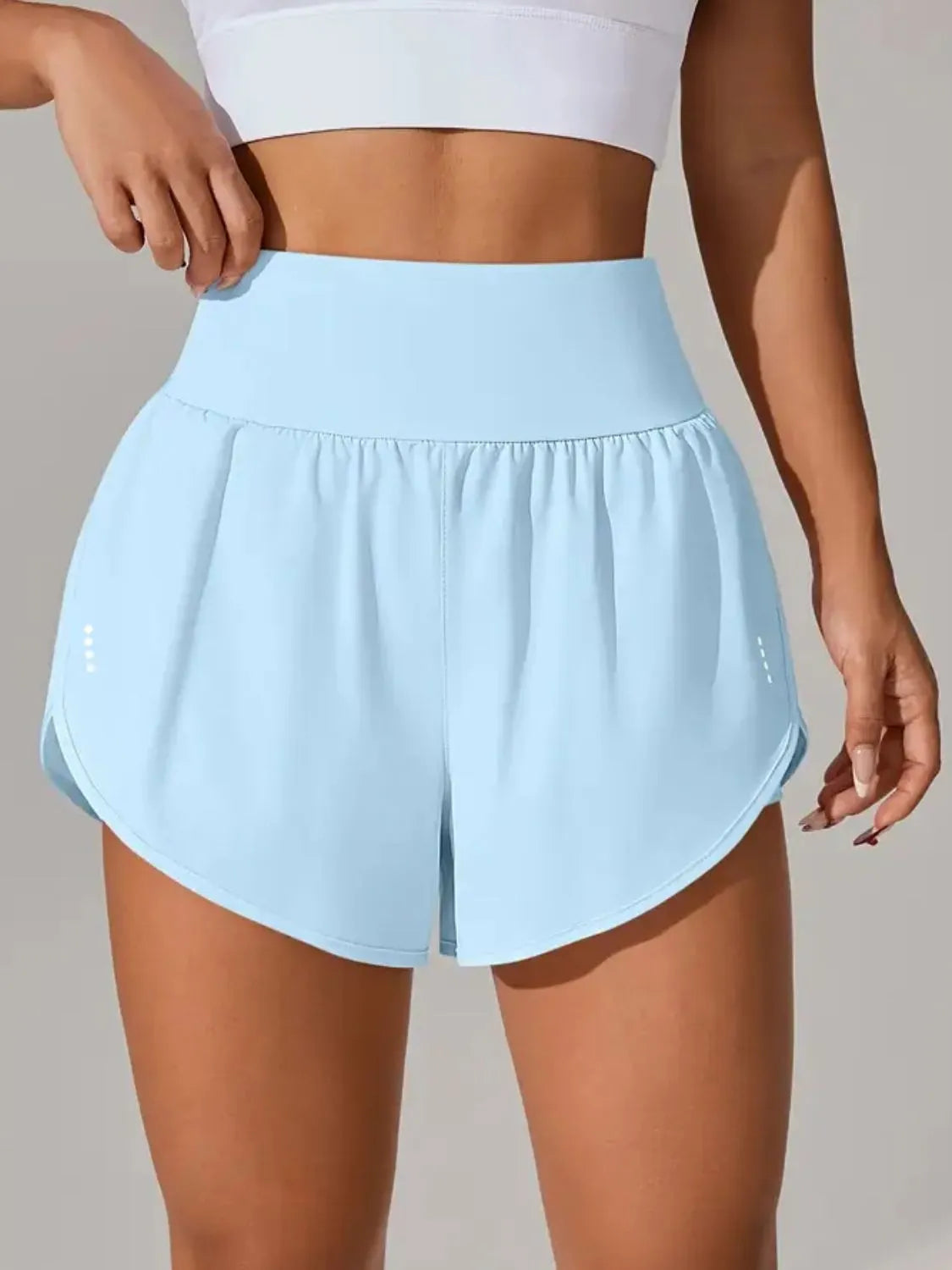 Light blue athletic shorts worn by a person on a neutral background