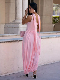 Woman in a pink dress standing in front of classical architecture