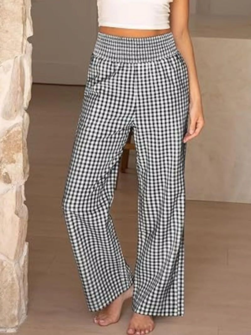 Person wearing black and white checkered pants in a neutral setting