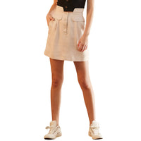 A woman wearing a high waisted beige utility skirt with side pockets and a button fly. She is also wearing a black top and white sneakers.