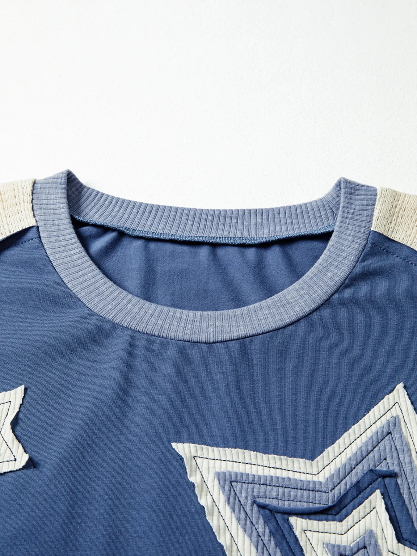 Close-up of a blue shirt with star designs on a white background