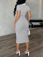 Woman wearing a black and white striped dress in an indoor setting.