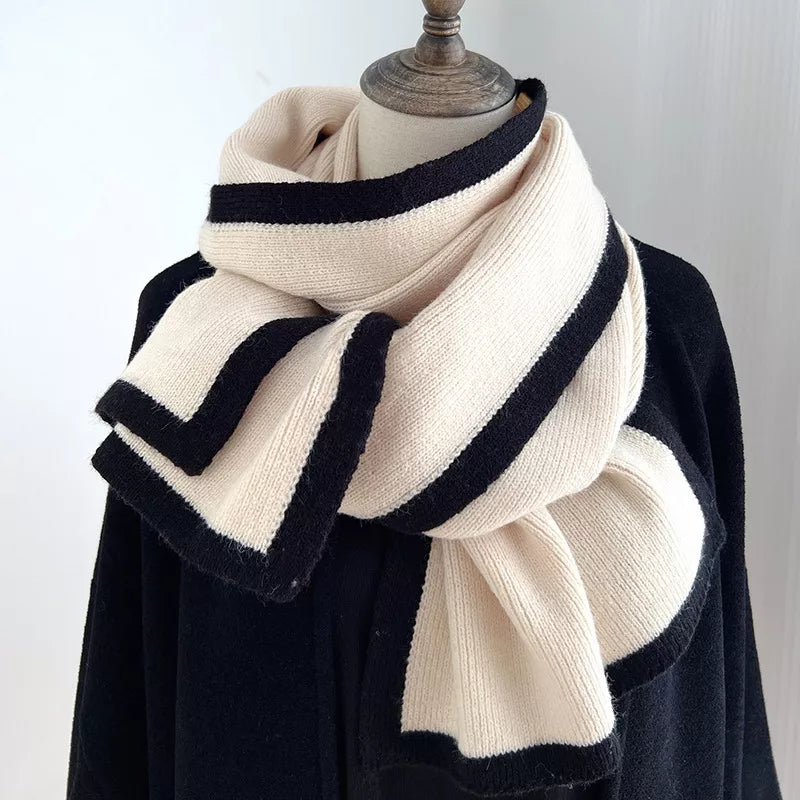 Black and white striped scarf on a mannequin against a plain background