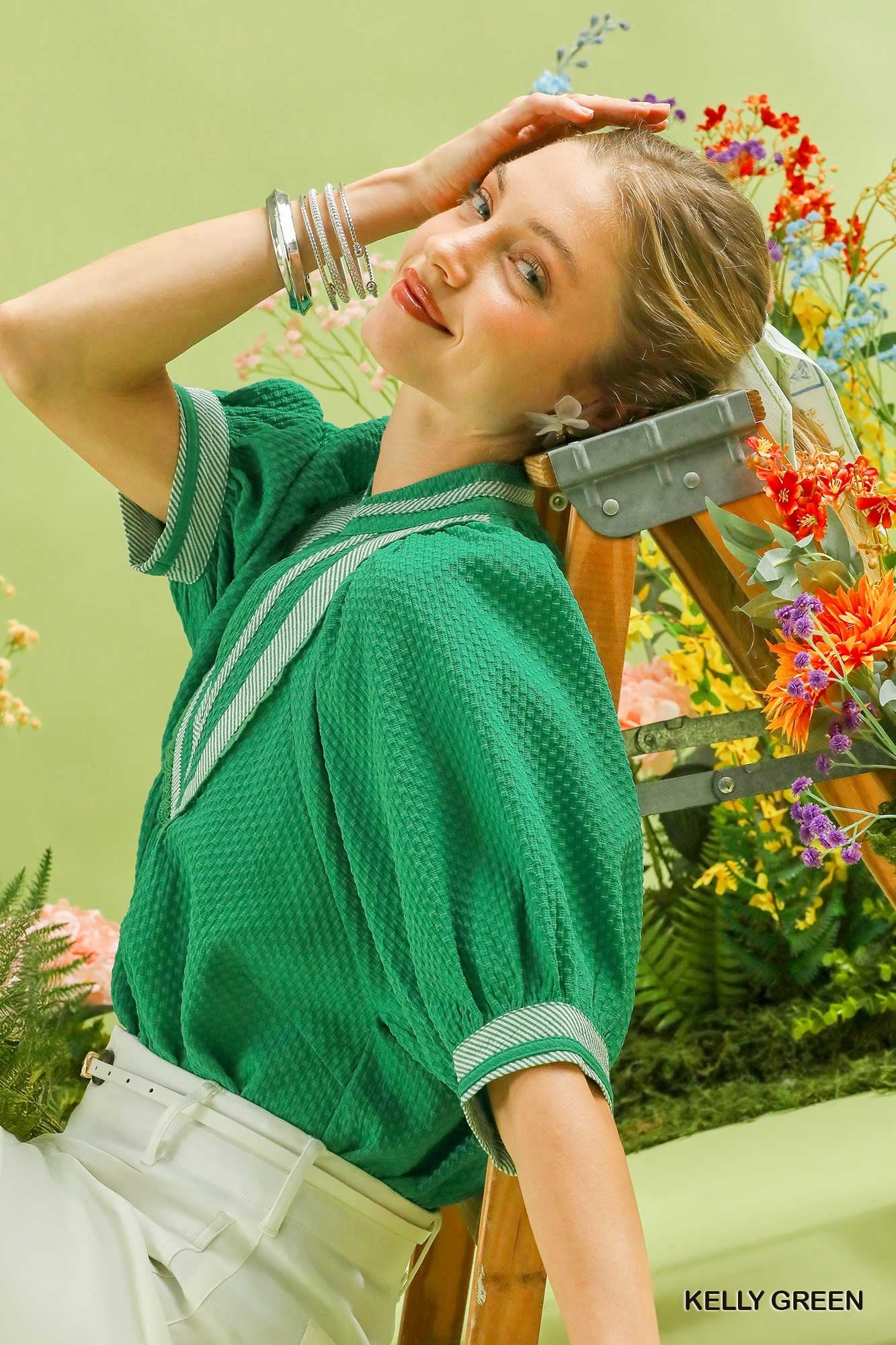 Woman in a green top with floral background