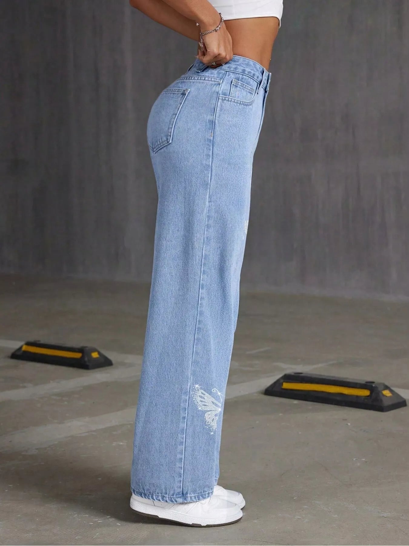 Light blue jeans worn by a person on a gray floor.