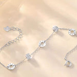 Silver bracelet with various charms on a light gold background