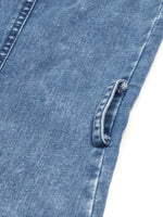 Close-up of blue denim fabric with a button on a white background