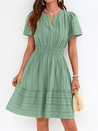 Green dress worn by a person on a white background
