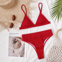 Red bikini set on a textured surface with decorative elements