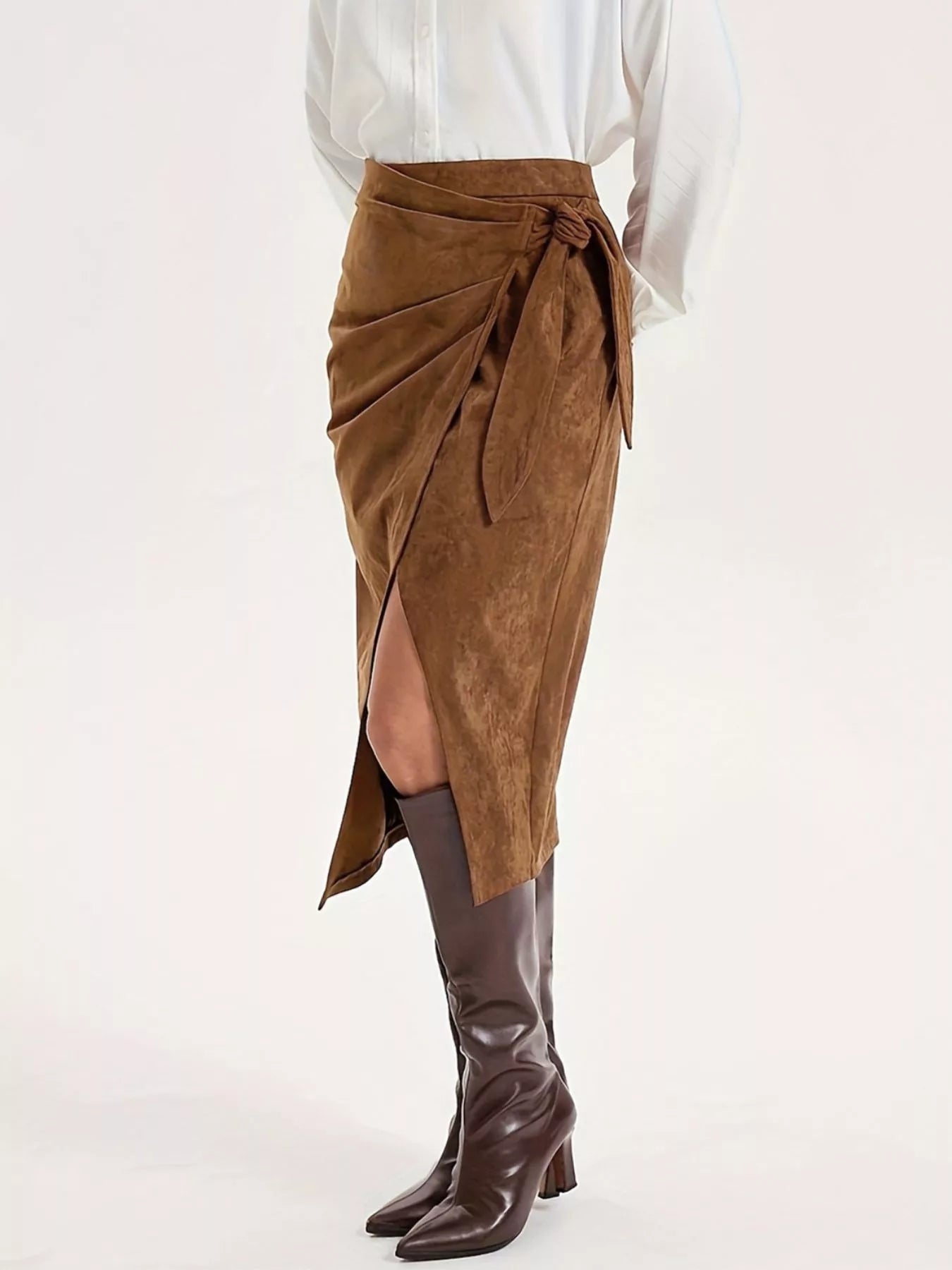 Brown suede wrap skirt with a white shirt and brown knee-high boots on a white background