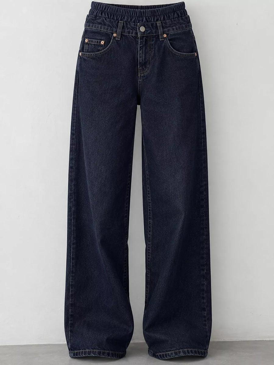 Dark navy blue wide-leg denim jeans with an elastic waistband, displayed against a plain light gray wall.