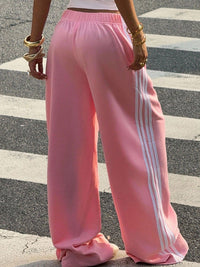 Person wearing pink Adidas tracksuit pants on a zebra crossing