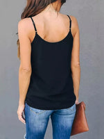 Person wearing a black tank top and blue jeans against a gray background