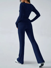 Person wearing a navy blue outfit with wide-leg pants on a white background