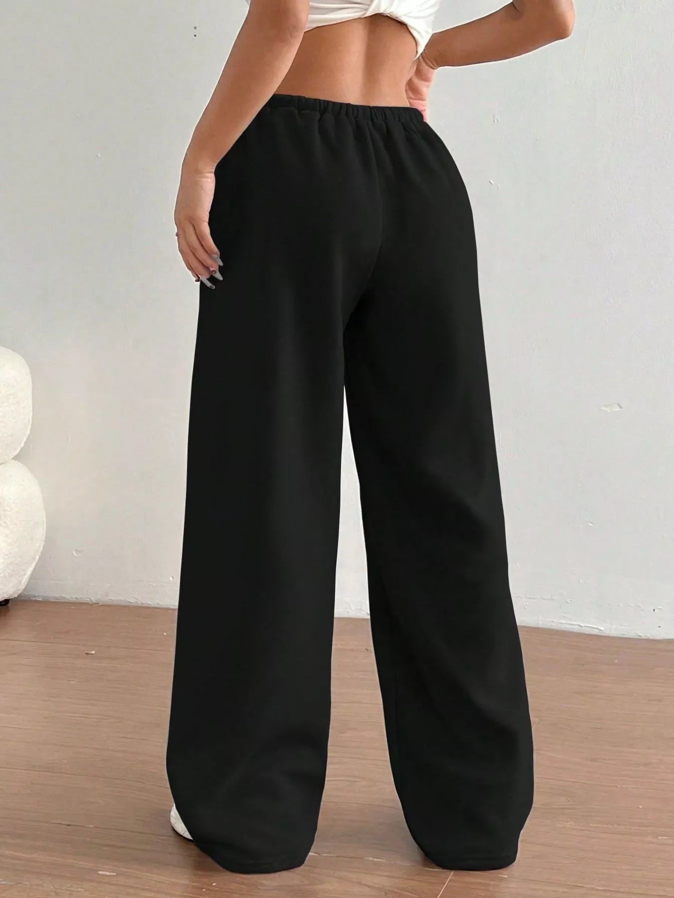 Black wide-leg pants worn by a person on a plain background