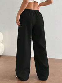 Black wide-leg pants worn by a person on a plain background