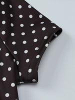 Close-up of a brown fabric with white polka dots on a light gray background