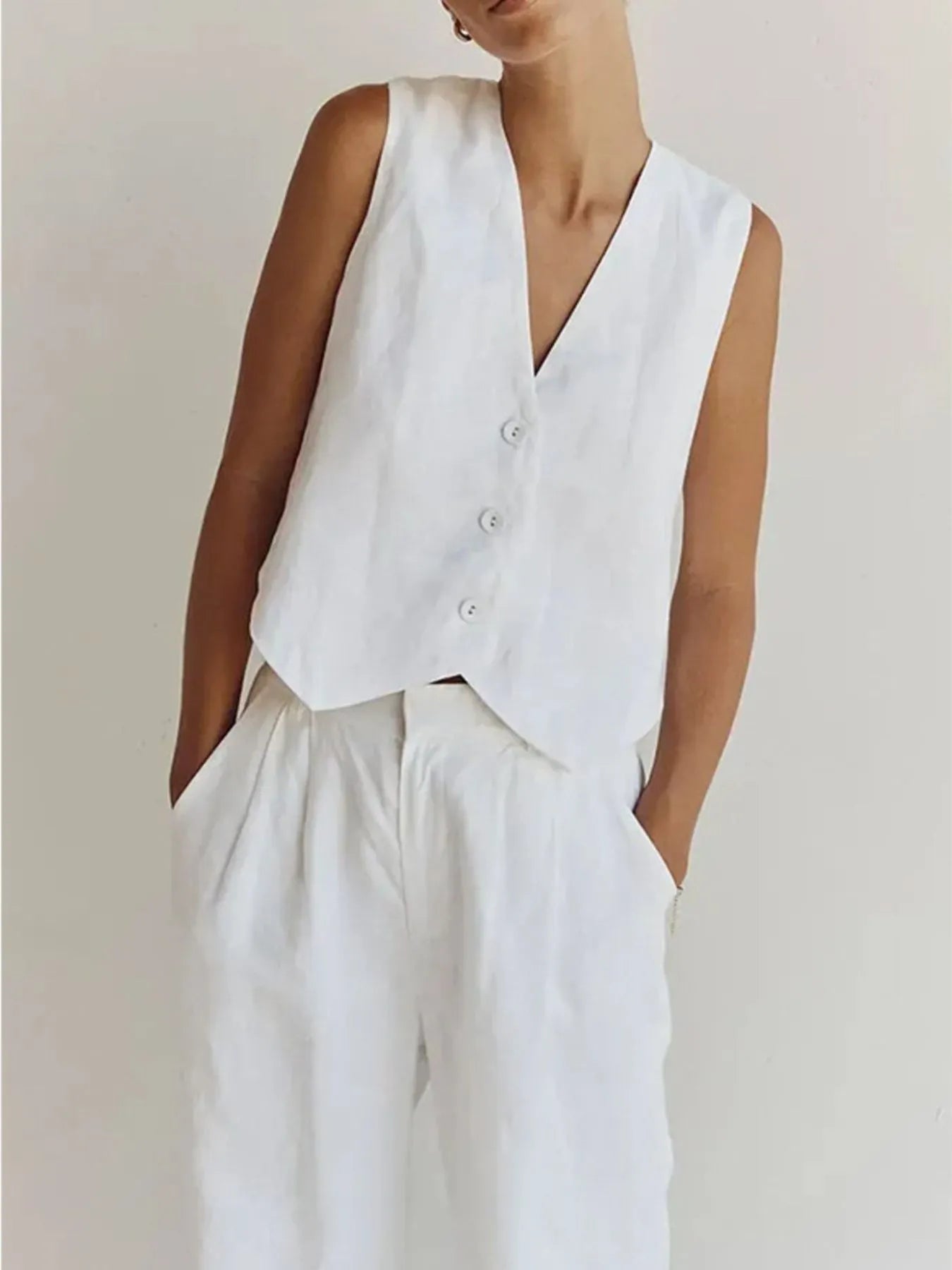 Person wearing a white vest over a plain background